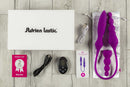 Adrien Lastic 2X Double Ended Vibrator set with remote, warranty card, charging cable, and storage pouch on wooden surface.