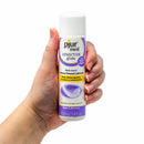Hand holding Pjur Med Sensitive Glide Water-Based Lubricant 3.4 oz bottle, suitable for sensitive skin and mucous membranes.