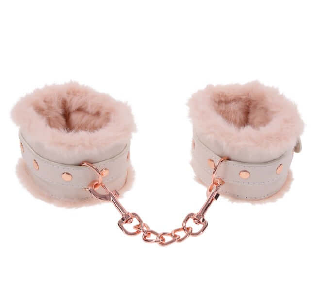 Peach-colored faux fur handcuffs with rose gold chain for luxury bondage play.
