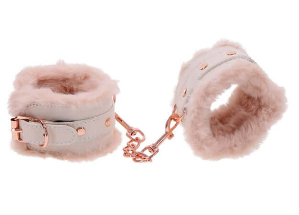 Peach-colored faux fur handcuffs with rose gold accents for luxury bondage.
