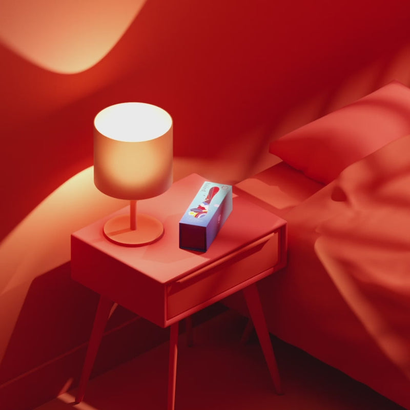 Biird Gii Glow Vibrator Lilac on a bedside table with a lamp and red decor