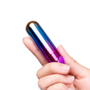 Le Wand Essentials Rechargeable Rainbow Bullet Vibrator held in hand showcasing its sleek design and vibrant colors.