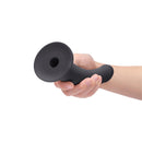 B-vibe Essentials 7 Inch Smooth Silicone Dildo Black held in hand, showcasing its sleek design and smooth texture.
