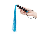 B-vibe Essentials Beaded Flogger with black beads and blue falls in hand for textured impact play.
