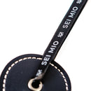 Close-up of the Sei Mio Double Trouble Shhh Oops Double-Sided Paddle tag showcasing elegant design and branding.