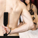 Sei Mio Double Trouble Shhh Oops Double-Sided Paddle held by a person, adding a playful touch to impact play.