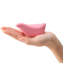 Tenga Iroha+ Tori Nadeshiko Clitoral Vibrator in a hand showcasing its small bird shape and soft pink color.
