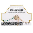 Sex & Mischief Indica Crystal Day Collar featuring green crystals and gold chain on packaging.