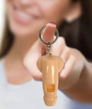 Super Fun Penis Whistle Key Chain held by smiling person against a blurred background.