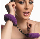 Woman wearing Master Series Cuffed in Fur purple furry handcuffs, soft and adjustable with keys, enhancing intimate moments and bondage play