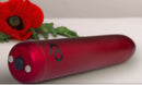 Poppy Red Rechargeable Bullet Vibrator on a neutral background with a red poppy flower.
