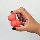 Hand holding Unihorn Mini Peachy Pony Vibrator, a small unicorn-shaped rechargeable vibrator with 10 speeds for personal pleasure.