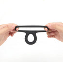Maia Gavin Black Liquid Silicone C Ring held in hands, showcasing its stretchy double ring design.