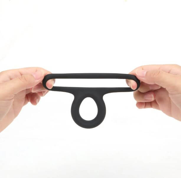 Maia Gavin Black Liquid Silicone C Ring held in hands, showcasing its stretchy double ring design.