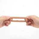 Two hands holding a Maia Gunner Caramel Liquid Silicone C ring, showcasing its flexible design and premium material.