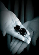 Fetish Fantasy Glass Ben-Wa Ball Medium 1.25 Inch Black held in hands showcasing its elegant design.