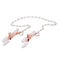 Adjustable rose gold chain nipple clamps with elegant pearl accents and white rubberized tips for intimate play.