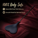 Temptasia Ardor Silicone Heart Crop Black on a luxury fabric, showcasing a heart-shaped tip and sleek design.