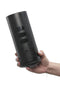 Hand holding the Titan by Kiiroo, a black handheld stroker with touch-sensitive vibration technology.