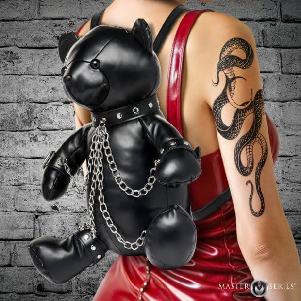 Master Series BDSM Bear Backpack Black worn on a model featuring a bear in bondage gear with chains and soft black finish.