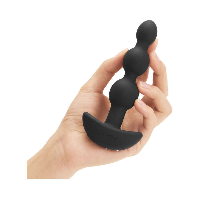 b-Vibe Triplet Remote Controlled Anal Beads Plug Black held in hand, showcasing three flexible beads for enhanced pleasure.