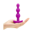 b-Vibe Triplet Remote Controlled Anal Beads Plug Fuchsia held in hand, showcasing its tapered beads design.