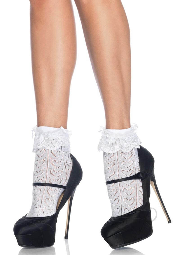 White crochet ankle socks with lace ruffles paired with stylish black platform heels, showcasing a chic and trendy look.