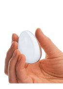 Glas Yoni Eggs 2 Piece Kegel Exerciser Set Clear smooth glass egg held in hand for pelvic floor strengthening.