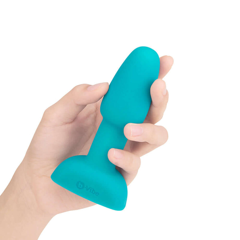 b-Vibe Rimming Petite Rotating and Vibrating Remote Control Plug Teal held in hand, showcasing its smooth design.
