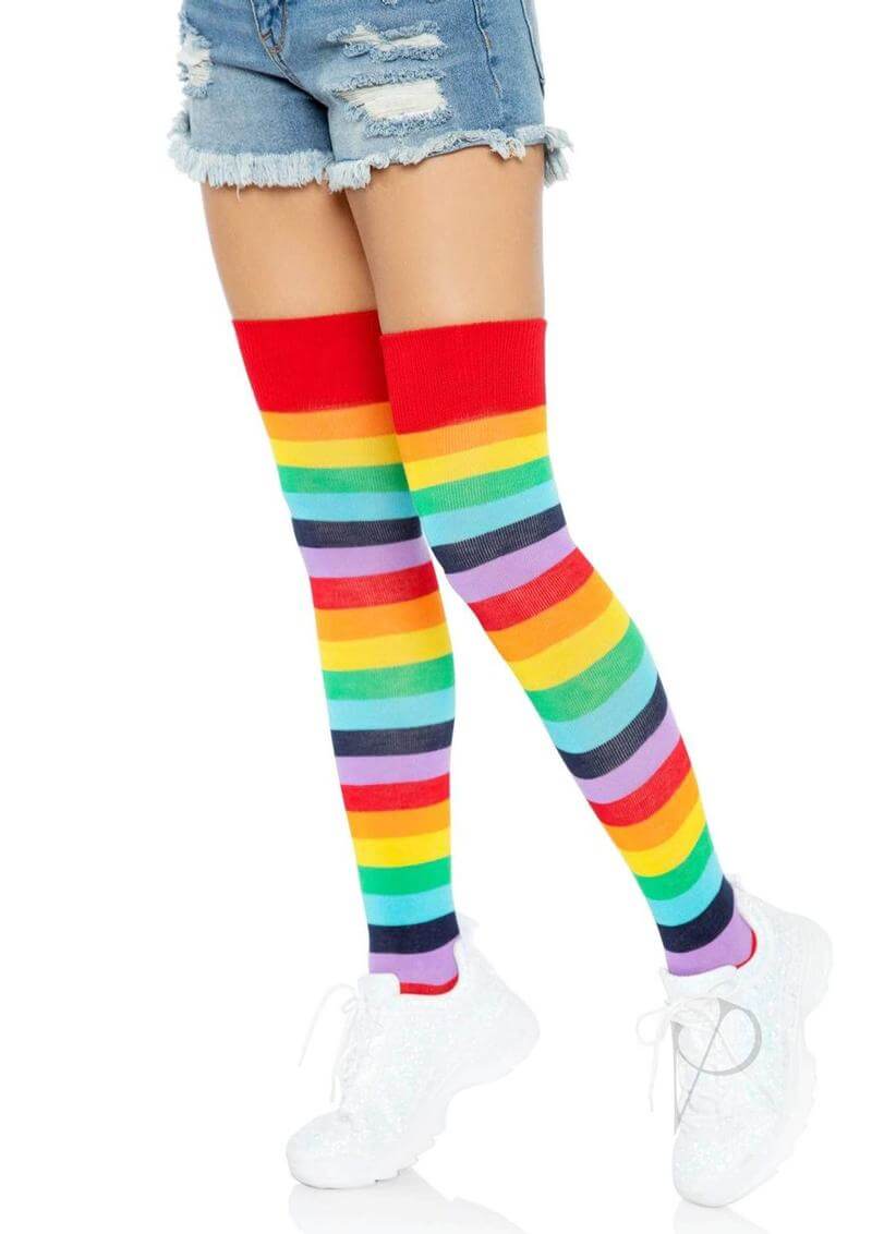 Model wearing Leg Avenue rainbow thigh high socks with multicolor stripes, paired with denim shorts and white sneakers.