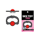Wood Rocket Ball Gag Soft Enamel Lapel Pin shown in side view with packaging, perfect for playful accessory lovers.