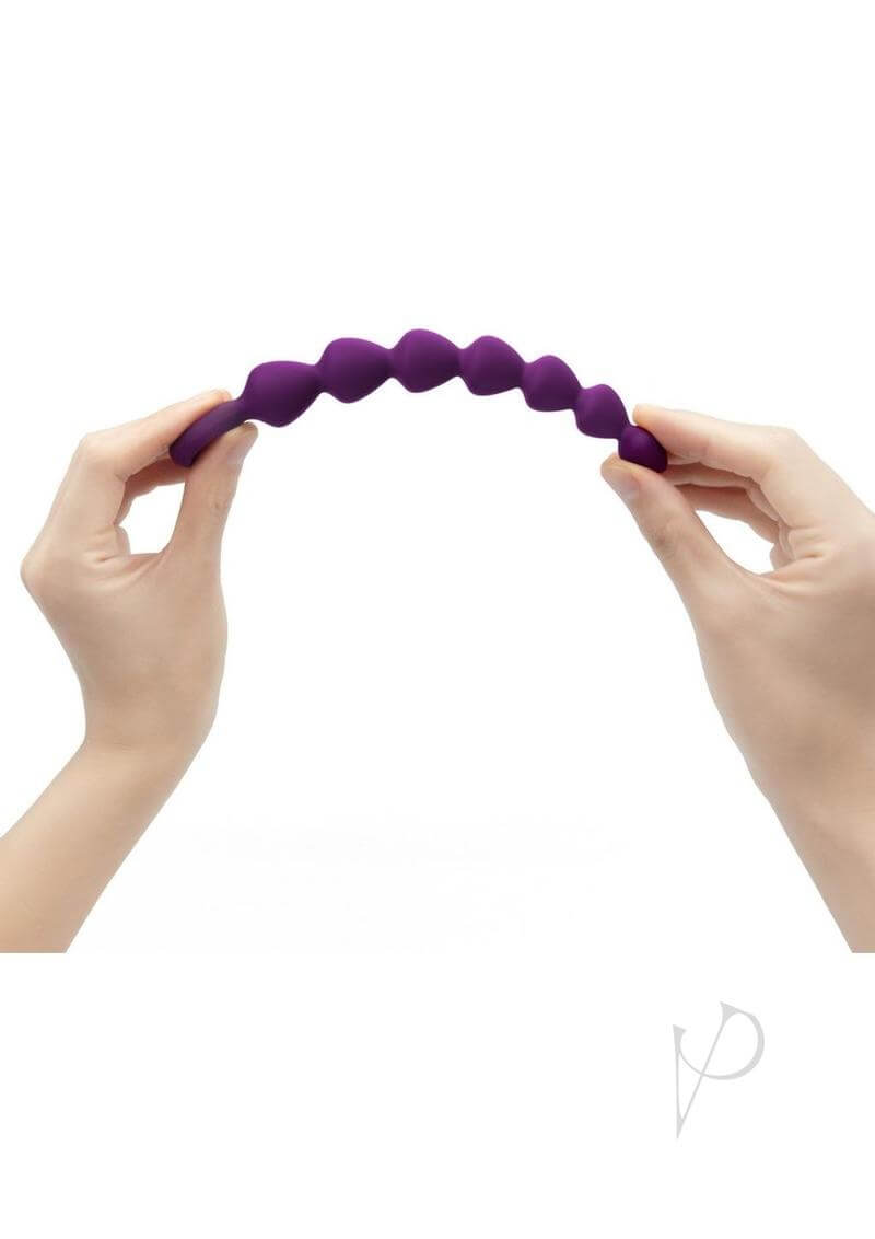 Bing Bang Silicone Anal Beads Small Purple being flexed, showcasing its flexible design for pleasure.