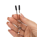 Fifty Shades Freed All Sensation Nipple & Clitoral Chain being held in a hand with decorative elements visible.