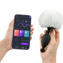 Magic Motion Magic Bunny Vibrating Anal Plug with Tail in hand, displaying app controls for smart features.