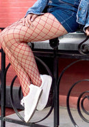 Model wearing Leg Avenue Spandex Diamond Panty Hose in red, styled with a denim jacket and shorts.