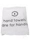 White hand towel with text "hand towels are for hands" and a minimalist logo above.