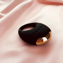 Edonista Luca Vibrating Penis Ring Black on soft pink fabric, designed for enhanced pleasure and comfort.