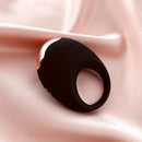 Edonista Luca Vibrating Penis Ring Black on satin fabric, showcasing its sleek design and quality material.