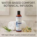 Moonbloom Natural Water Comfort Glide Extra Sensitive 8 Oz bottle on a bathroom countertop with towels and flowers.