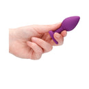 Ouch Silicone Diamond Heart Butt Plug Purple Regular held in a hand, showcasing its tapered design and vibrant color.