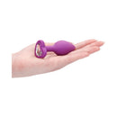 Ouch Silicone Diamond Heart Butt Plug Purple Regular in a hand highlighting its tapered shape and diamond accent.