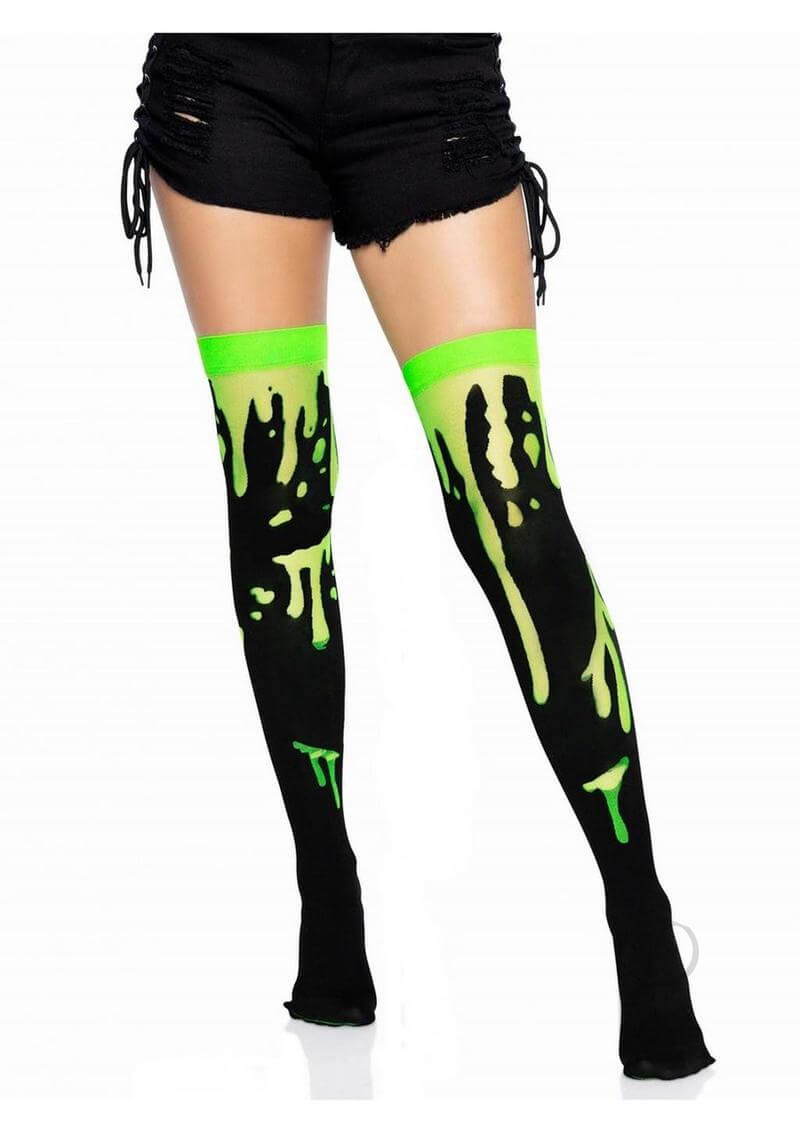Leg Avenue Splatter Thigh Highs OS Green on model wearing shorts, showcasing vibrant splatter design in black and neon green.