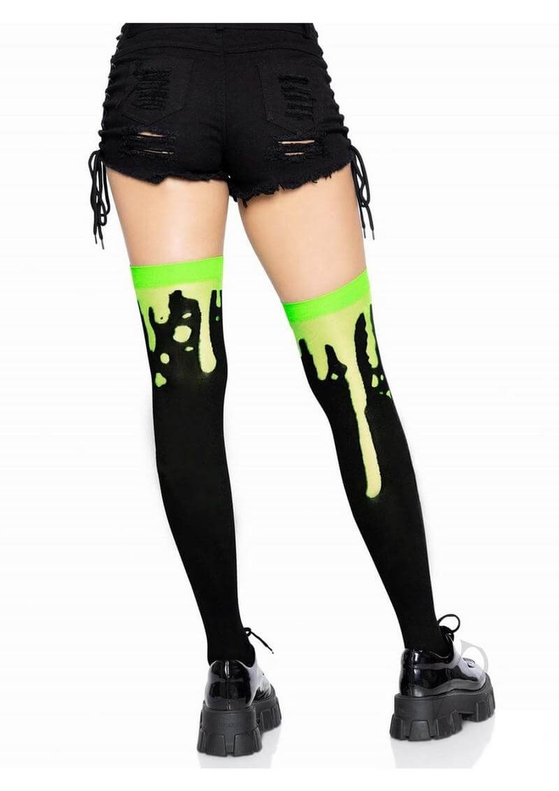 Leg Avenue Splatter Thigh Highs OS Green paired with black shorts, showcasing a unique splatter design in vibrant green.
