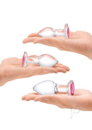 Glas Heart Jewel Glass Anal Training Set 3 Piece Clear displayed in hands, showcasing three different sized glass plugs.