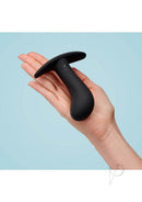 Hand holding black flexible silicone butt plug for prostate play