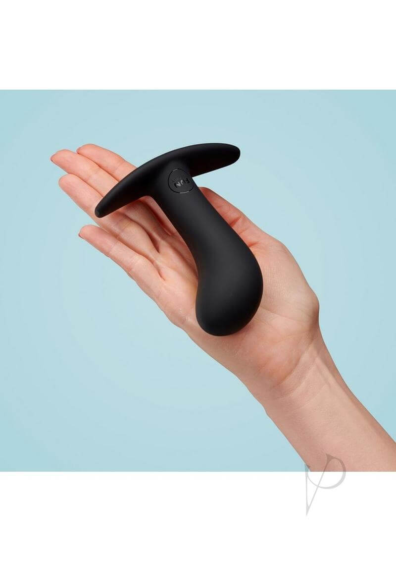 Hand holding black flexible silicone butt plug for prostate play