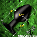 Creature Cocks Green Eye Silicone Butt Plug Medium with size dimensions on textured background.