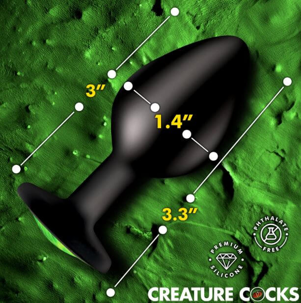 Creature Cocks Green Eye Silicone Butt Plug Medium with size dimensions on textured background.