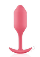 B-Vibe Snug Plug 2 Silicone Weighted Anal Plug Coral in vibrant coral pink color, designed for comfortable extended wear.