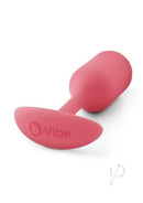 B-Vibe Snug Plug 2 Silicone Weighted Anal Plug Coral viewed from above on a light background.